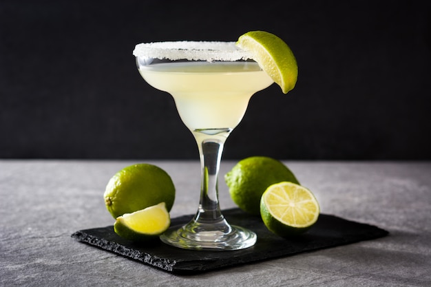 Margarita cocktails with lime in glass on gray