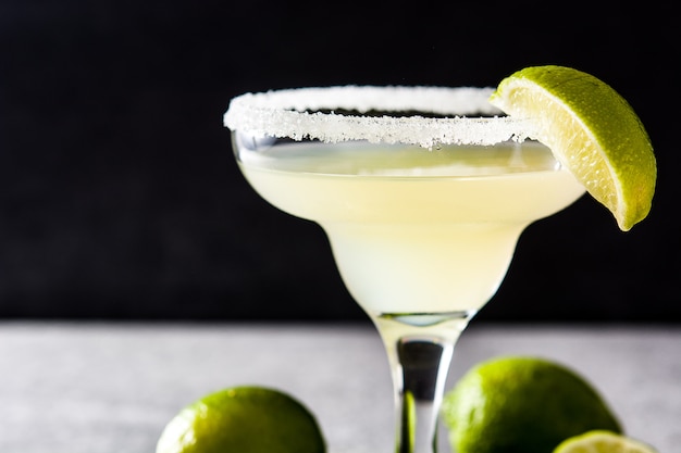 Margarita cocktails with lime in glass on gray