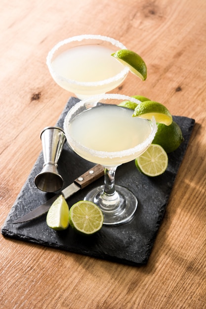 Photo margarita cocktails with lime in glass on wooden table