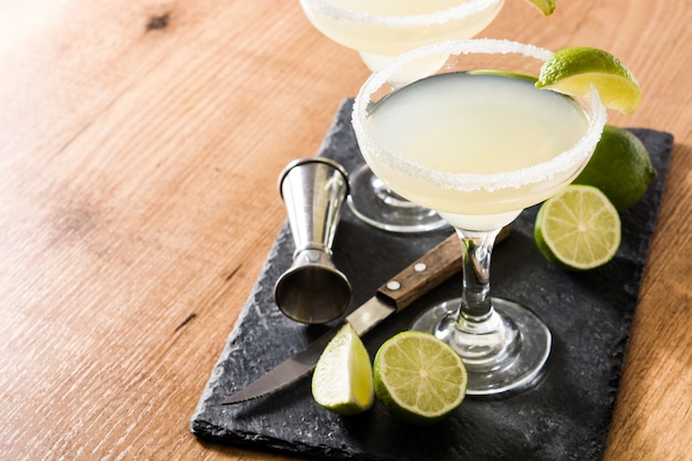 Margarita cocktails with lime in glass on wooden table