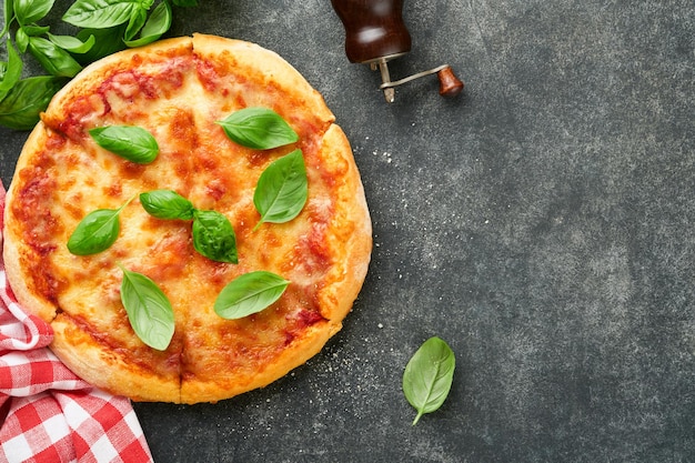写真 マルガリータ ピザ ナポリの伝統的なマルガリタ ピザと調理材料 トマト バジル 古いコンクリートの質感 背景のテーブル イタリアの伝統的な食べ物 トップビュー モックアップ