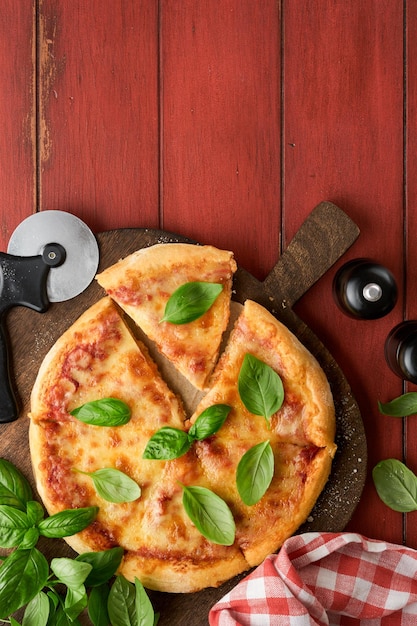 マルガリタピザ 伝統的なナポリのマルガリタピザと調理材料 トマト バジル 木製のテーブルの背景で イタリア 伝統的な食べ物 トップビュー モックアップ