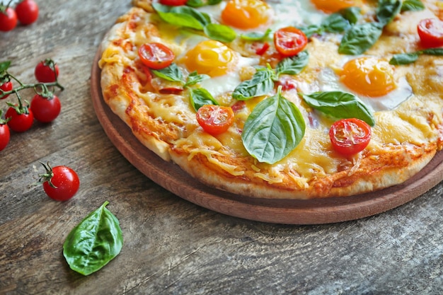 Margarita pizza with basil leaves and egg on wooden background