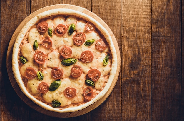 Margarita pizza at wooden table