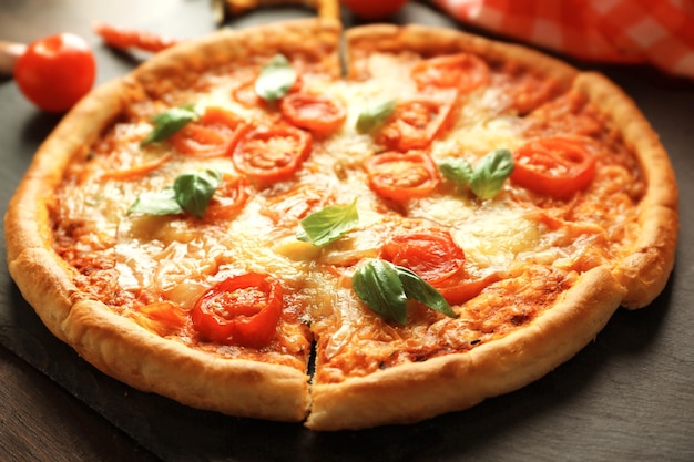 Margherita pizza with tomatoes on slate plate close up