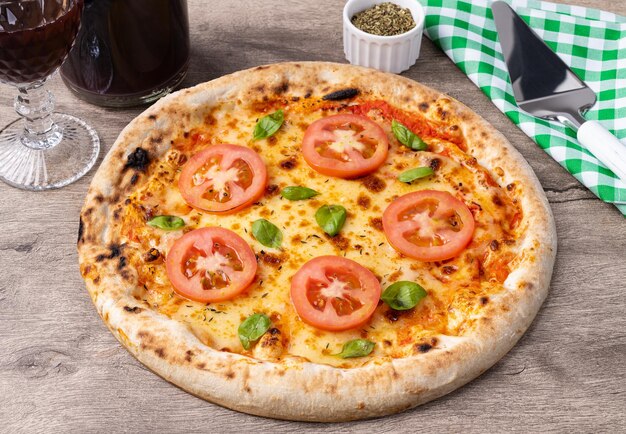 Margherita-stijl pizza over een houten tafel met wijn oregano en spatel