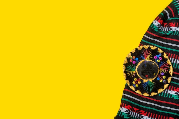 Photo mariachi hat and serape on yellow background mexican independence concept cinco de mayo background