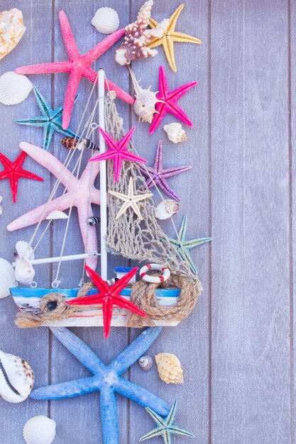 Mariene leven met schelpen, zeesterren en boot op houten planken