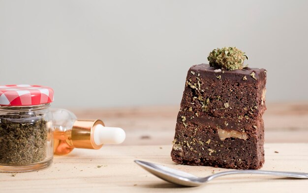 Marijuana brownie kitchen with cans of oil and jars with buds wooden table