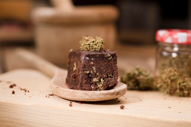 marijuana brownie on wooden spoon on kitchen table