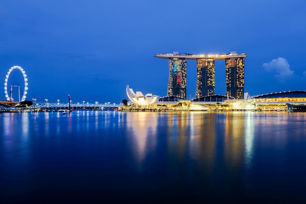 Photo marina bay sands by bay of water against sky in city at dusk