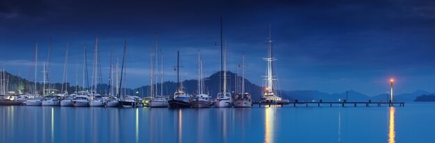 Marina at night with moored yachts