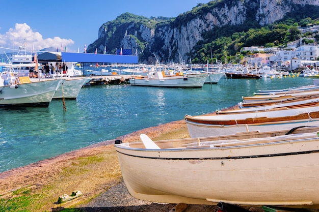 Marina with boats in Capri Island town at Naples in Italy. Landscape with Blue Mediterranean Sea at Italian coast. Anacapri in Europe. View on Faraglioni in summer. Amalfi scenery and Solaro mountain