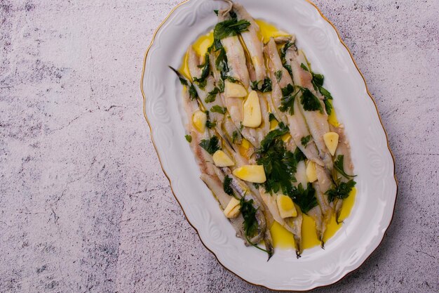 Marinated anchovies in vinegar and olive oil with parsley and garlic