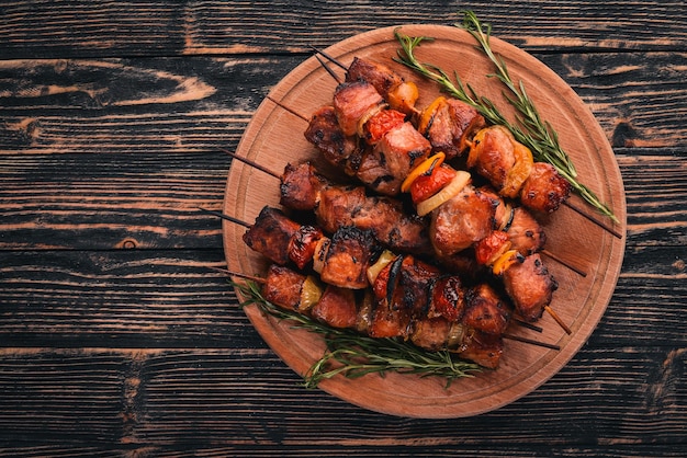 Marinated baked kebab with onions and spices On a wooden background Top view Free space for text