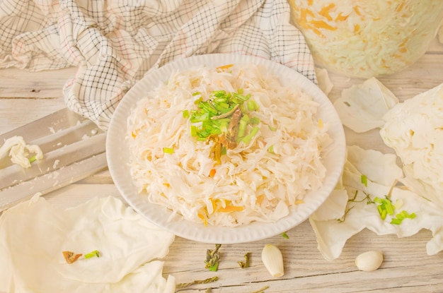 Marinated cabbage with carrots Sauerkraut with carrots in bowl on wooden background