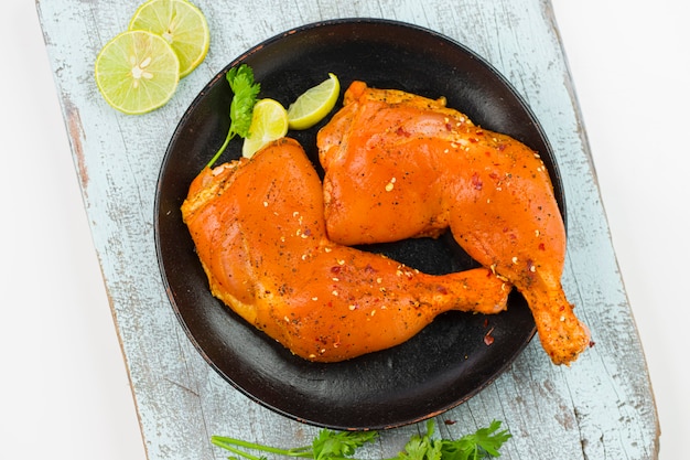 Marinated  chicken leg without skin arranged in a black plate