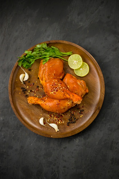 Marinated  chicken leg without skin arranged in a wooden base