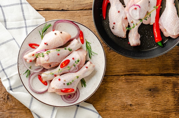 marinated chicken legs on wooden table background