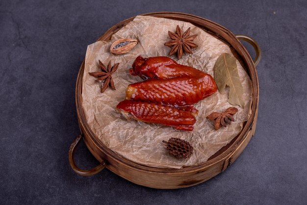 Marinated chicken wings on a plate against a dark background