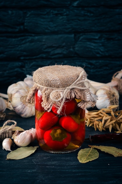 Marinated chili peppers in a jar Stocks of food Top view On a wooden background Copy space