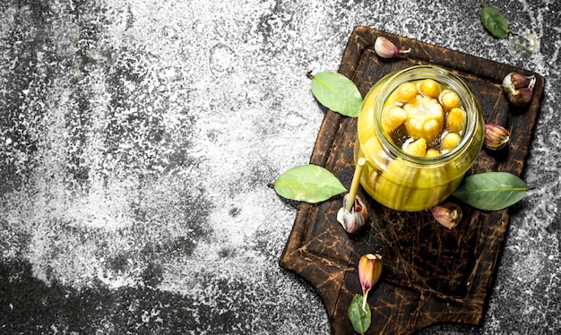 Marinated corn in glass jar. On a rustic background.