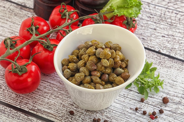 Marinated green capers condiment in the bowl