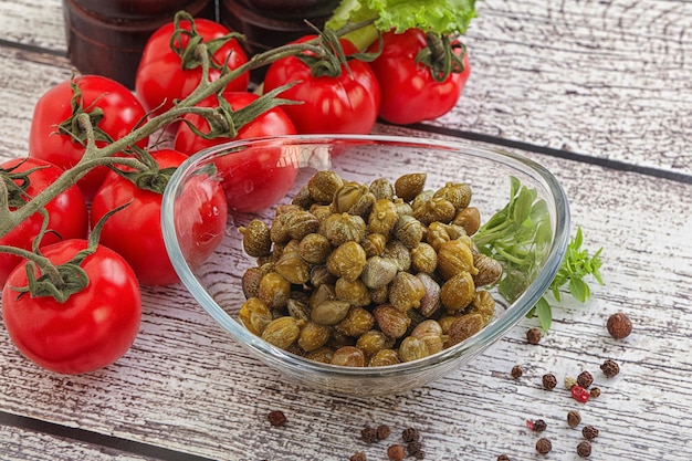 Marinated green capers condiment in the bowl