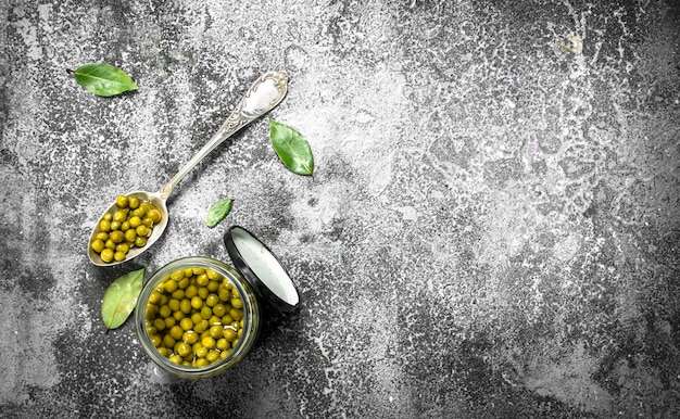 Marinated green peas in glass jar.