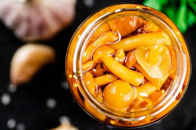 Marinated mushrooms with a glass jar with parsley and garlic