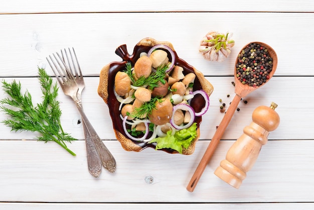 Marinated mushrooms with onions and spices in a plate. on rustic background, top view, banner.