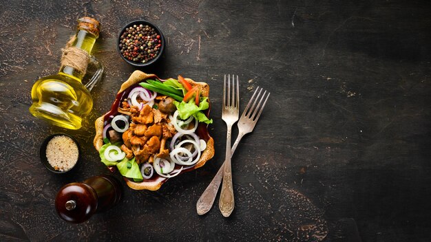 Marinated mushrooms with onions and spices in a plate on rustic background top view banner