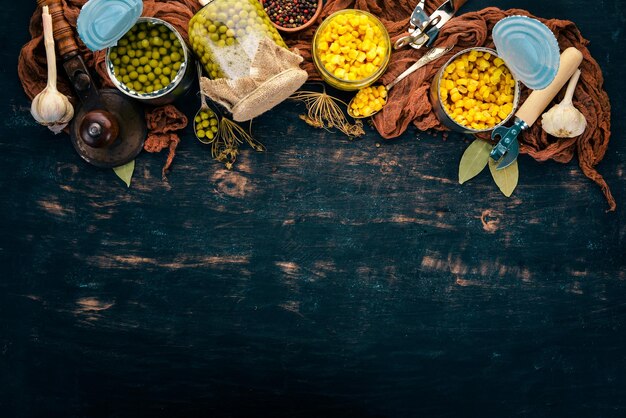 Marinated peas and corn in a jar Stocks of food Top view On a wooden background Copy space