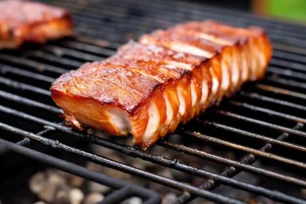 Marinated pork belly on top of a silver grill grate