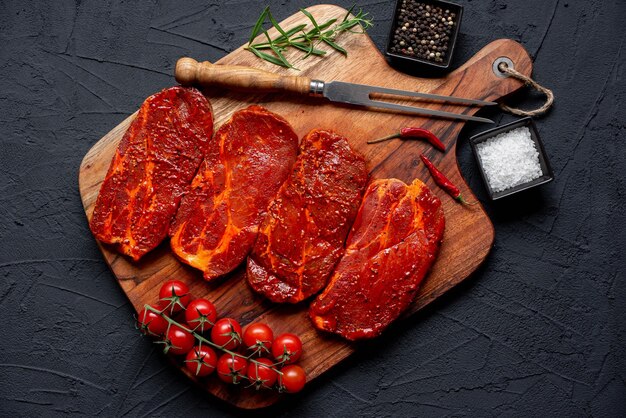 marinated raw pork steaks on stone background