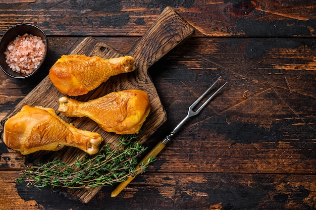 Marinated and Smoked chicken legs drumsticks on a wooden cutting board