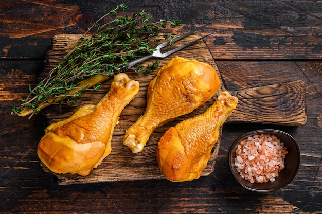 Marinated and Smoked chicken legs drumsticks on a wooden cutting board