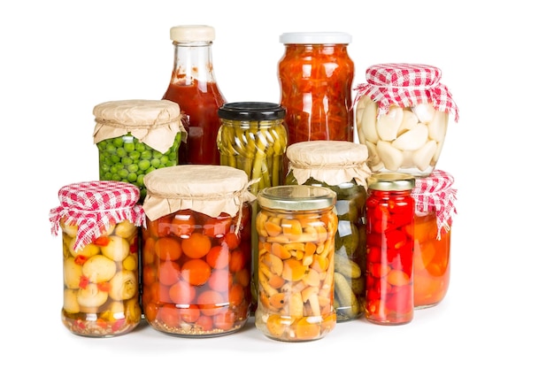 Marinated vegetables in glass jars isolated on white background