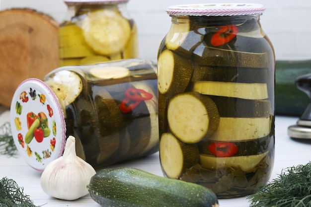 Foto zucchine marinate in barattoli di vetro situati sul tavolo, primo piano, orientamento orizzontale, raccolta delle verdure per l'inverno