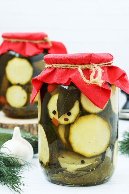 Marinated zucchini in glass jars on the table