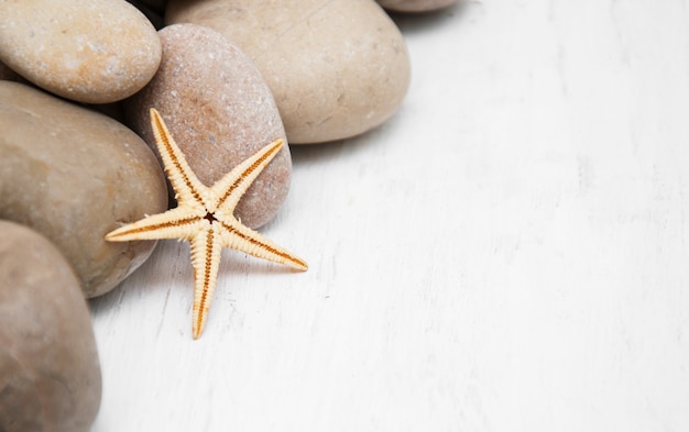 Marine background with pebbles and starfish