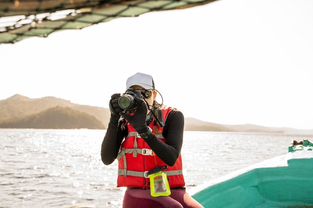 Marine biologist taking photos with a camera on a boat