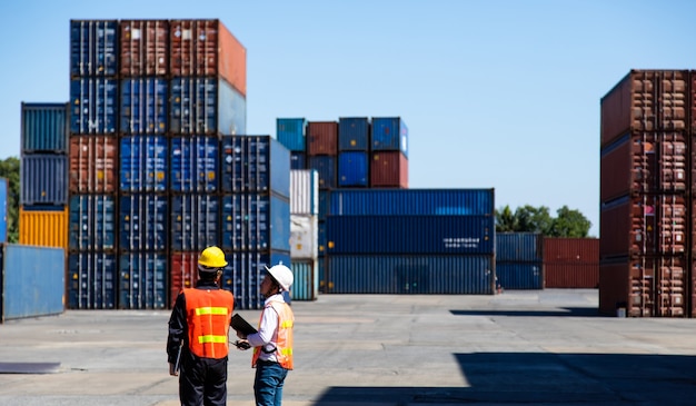 Marine and carrier insurance concept. Foreman control loading Containers box at shipping port. Business logistic Import and export concept.