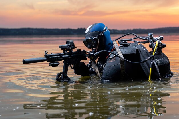 Морской пехотинец выходит из воды и движется к цели с оружием в руках. Понятие видеоигр, реклама, нестабильность в мире, страновые конфликты. Смешанная техника