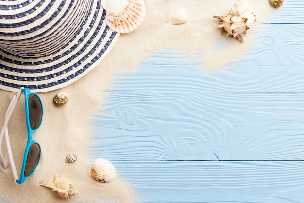 Marine concept. Beach accessories, sand and seashells on blue wooden table