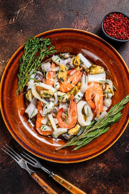 Marine seafood cocktail with shrimps, prawns, mussels, squids and octopus on a cutting board