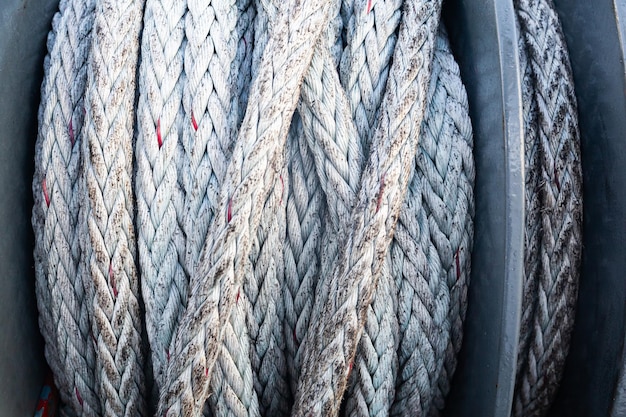 Marine ship winch for mooring operations with a rope wound around it closeup