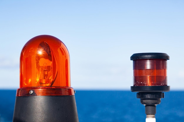 Marine signal light and emergency signal lamp turned off during the day against the sea and sky