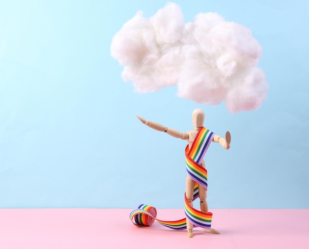 Marionet met regenboogband die pluizige wolk op pastelroze blauwe achtergrond drijft Creatief idee Minimaal lgbt-concept Pastelkleurentrend