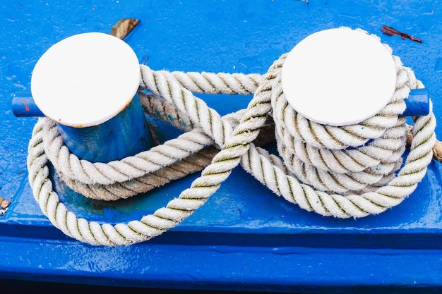 Maritim blue capstan with a rope attachd to it.